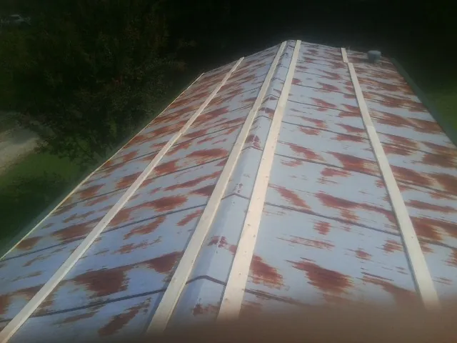 Rusted metal roof panels with new wood purlins before replacement — Storm Damage Roof Repair in Welcome by Roofing Brothers