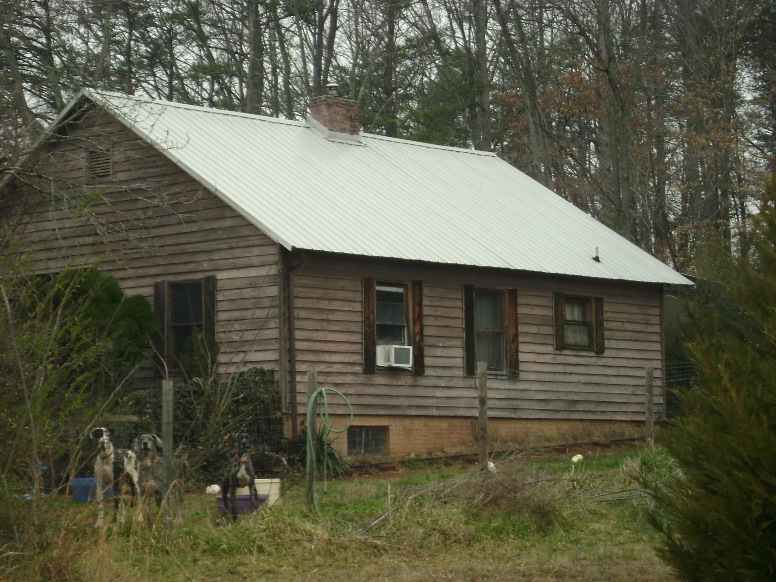 White metal roof on an old wood sided farmhouse, from a Metal Roof Installation job in Welcome
